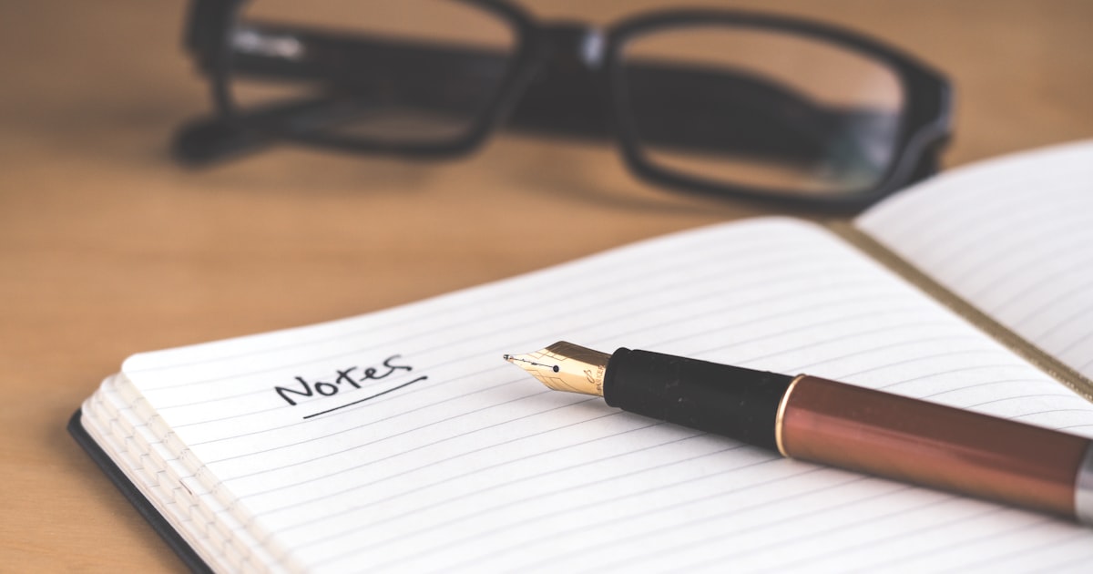 Carnet de notes ouvert avec un stylo plume, symbole d'une préparation concise