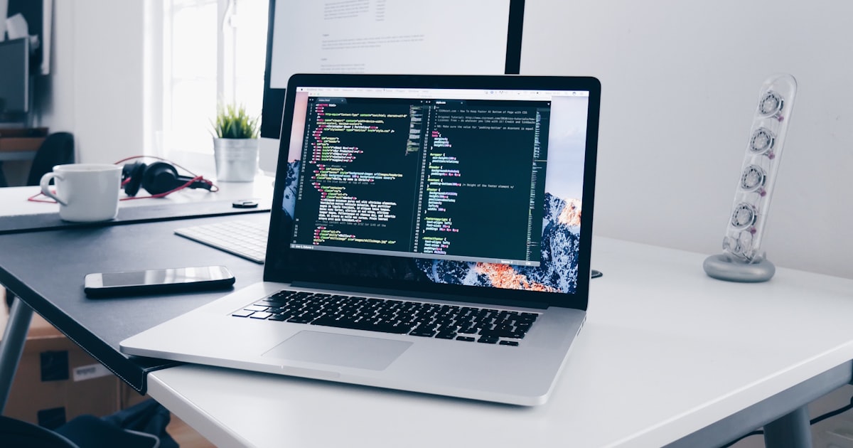 Poste de travail de développement : ordinateur portable affichant du code sur un bureau lumineux